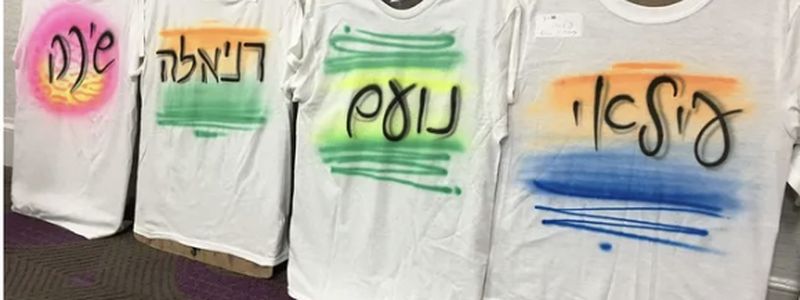 Row of custom airbrushed name shirts from an event